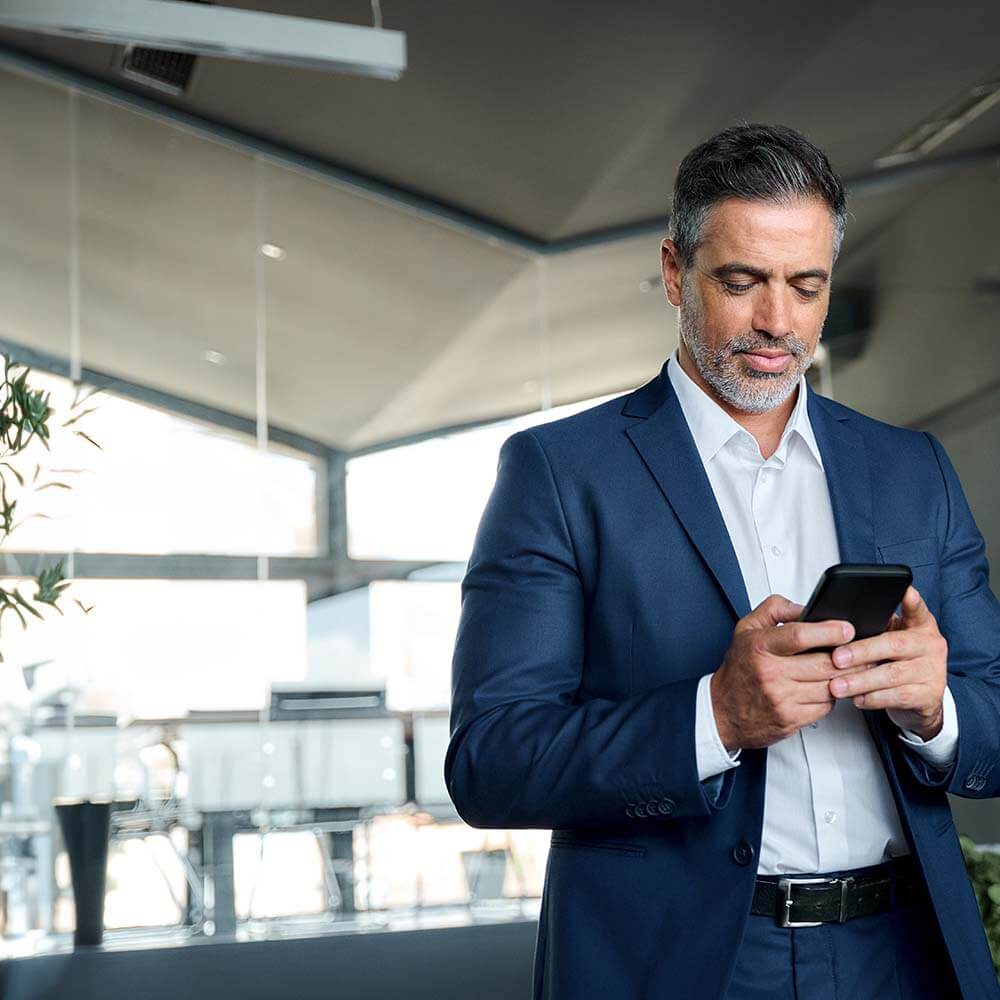 Professionnel en costume utilisant un réseau WiFi sécurisé pour consulter ses messages, illustrant une connexion Internet professionnelle fiable.